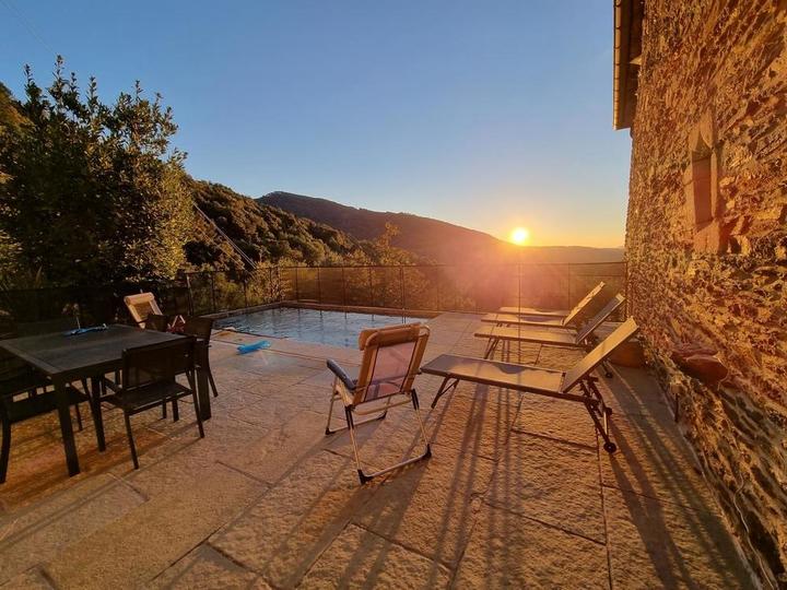 La terrasse, la piscine, le salon de jardin et les transats, au lever du jour.