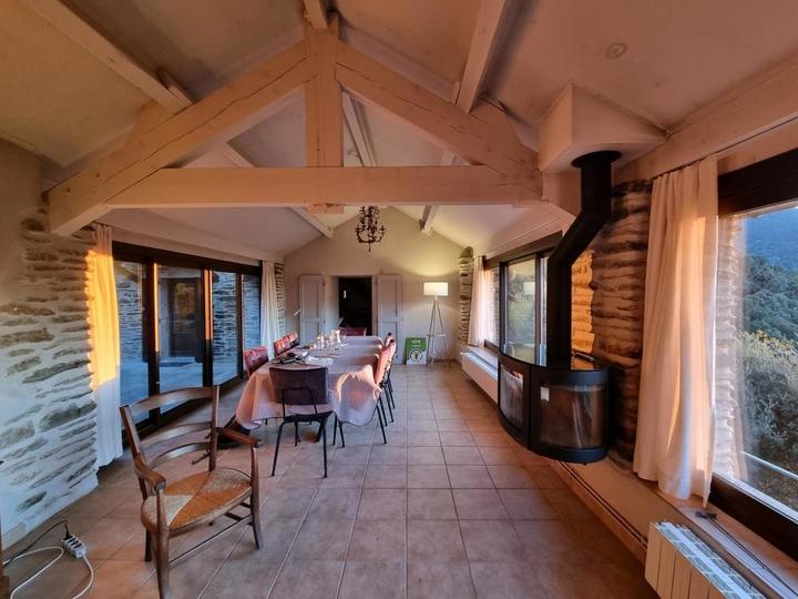 Le salon (vue du fond de la pièce), avec le poêle pour les soirées d'hiver. Les baies vitrées permettent de profiter directement de la vue panoramique.