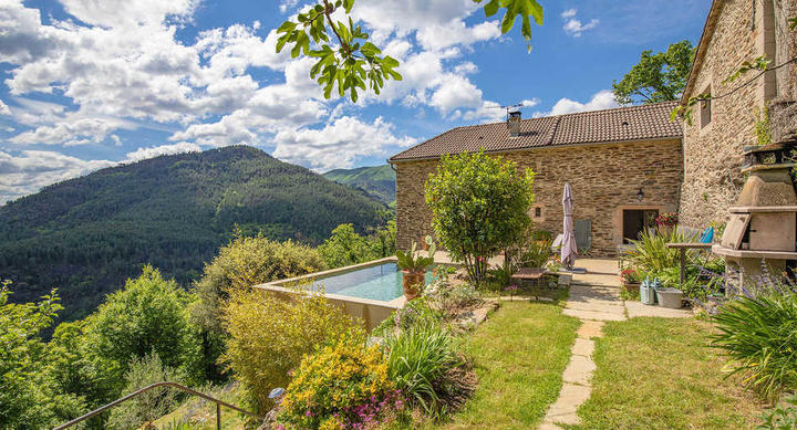 La maison, la terrasse et la piscine, vues du jardin.