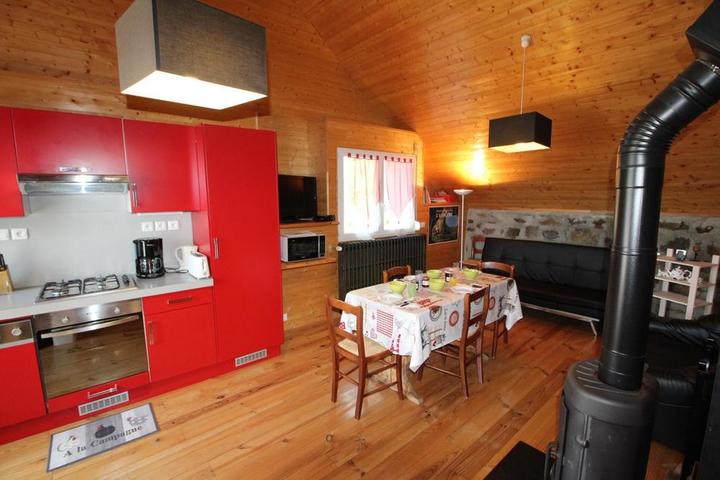 Pièce de vie cuisine équipée, séjour télévision et poêle à bois